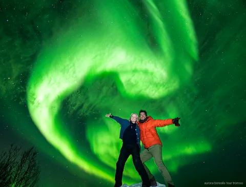 Gruppe der familiengeführten Minibus-Tour beobachtet die Nordlichter nahe Tromsø