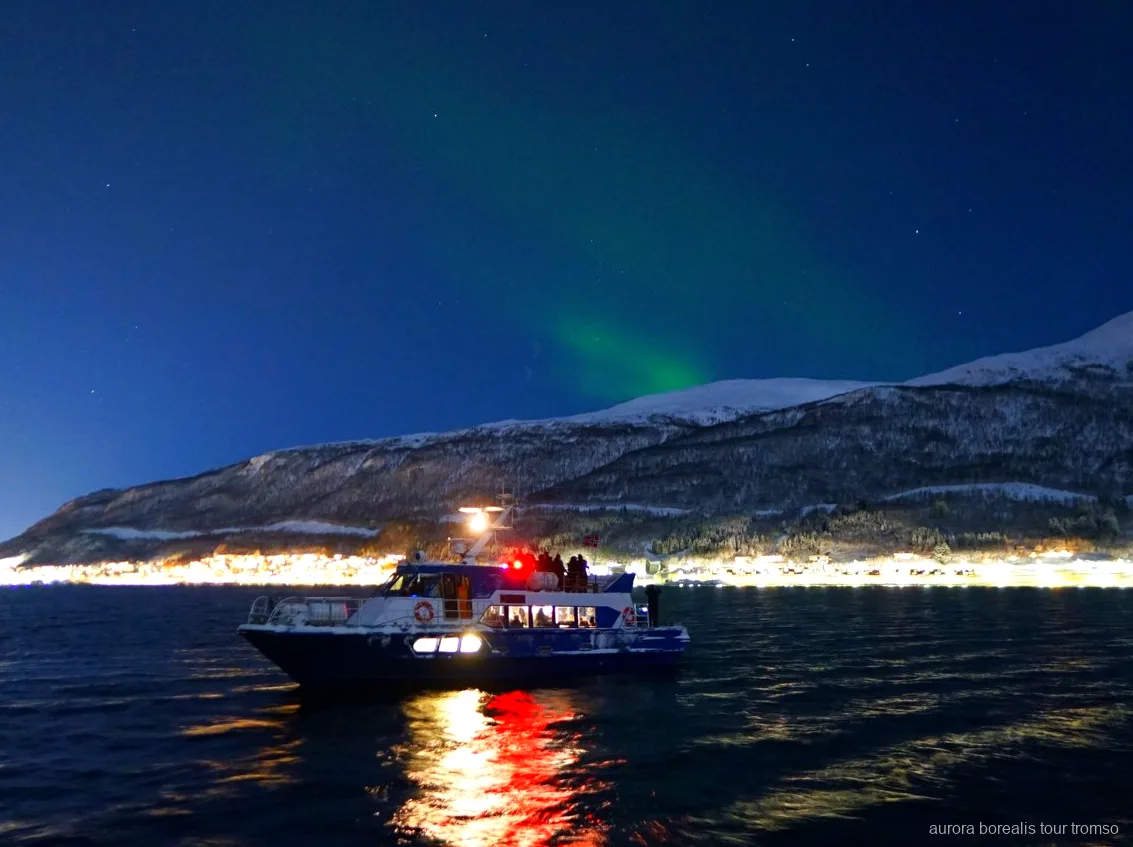 Crewmitglied hilft einem Gast bei den Kameraeinstellungen auf der Tromsø Aurora-Kreuzfahrt