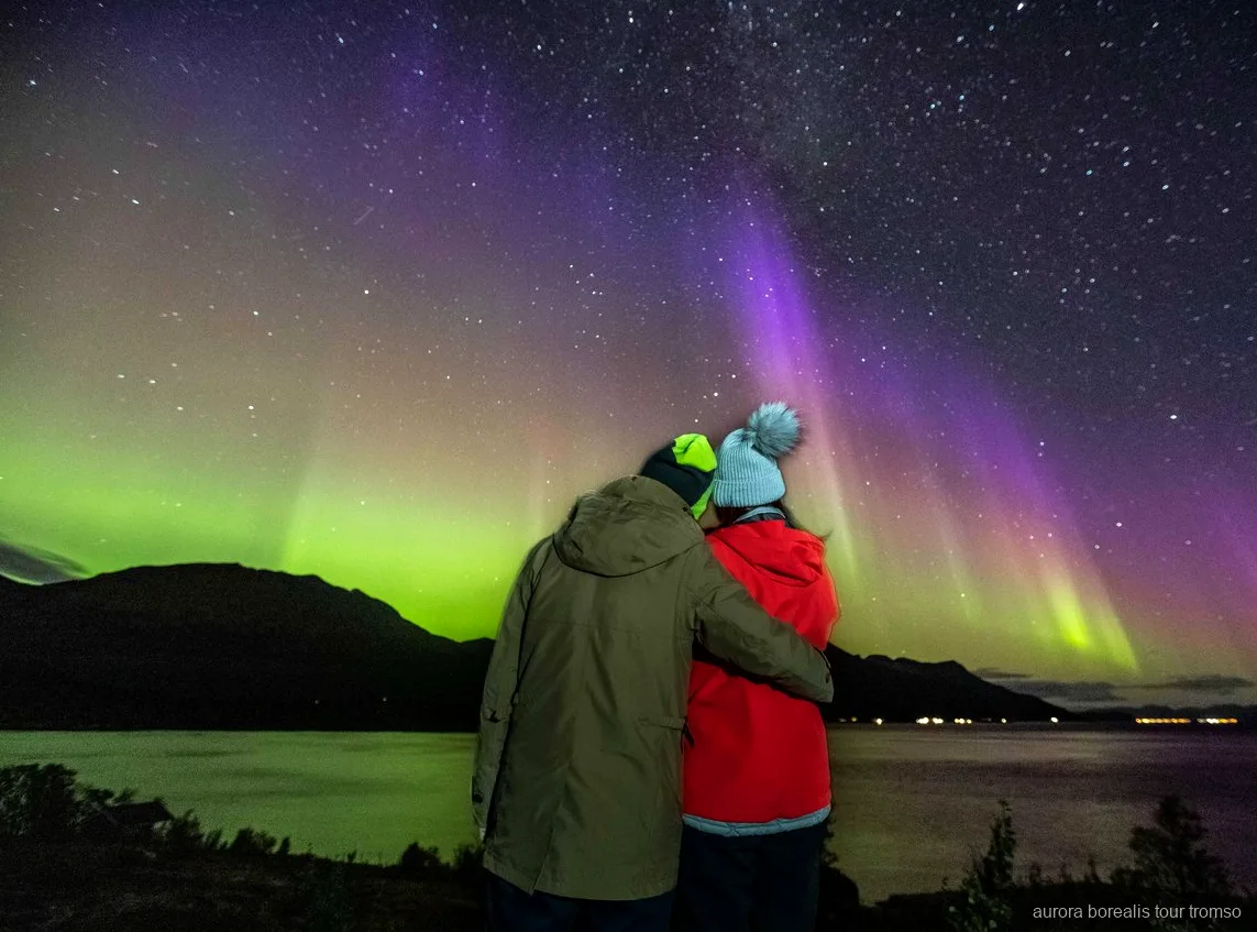 Guide tar ett porträtt av gäster under Tromsø norrskenjakt i liten grupp