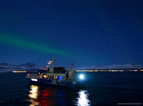 Tromso akşam kuzey ışıkları tekne turunda şehir iskelesinden kalkan tekne